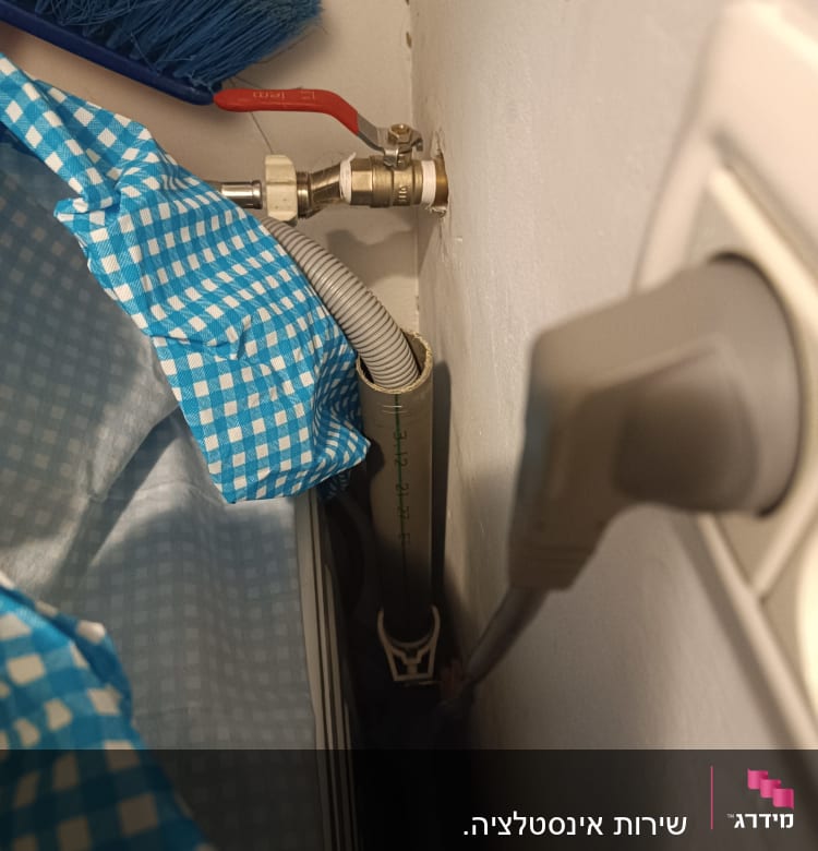 ברז עם ידית אדומה וצינור גמיש